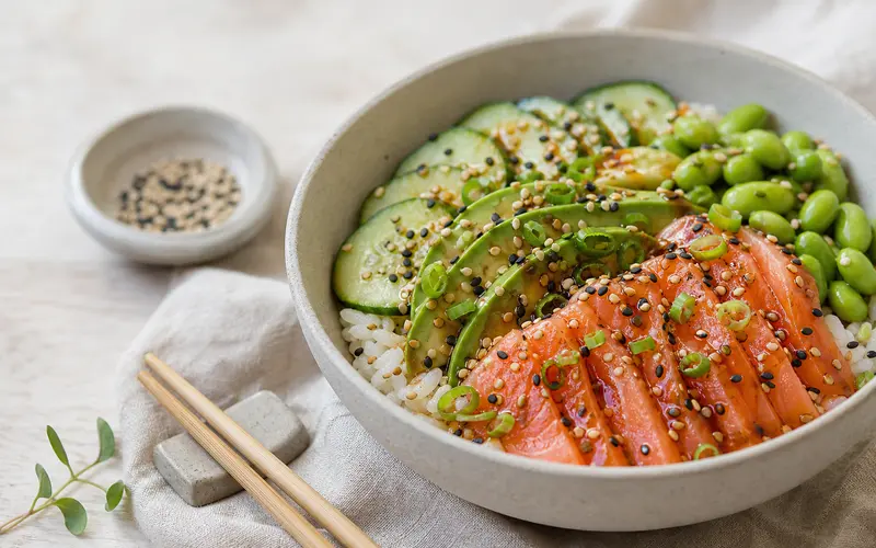 Bowl frais avec tranches de saumon fumé, avocat crémeux et rondelles de concombre sur riz vinaigré