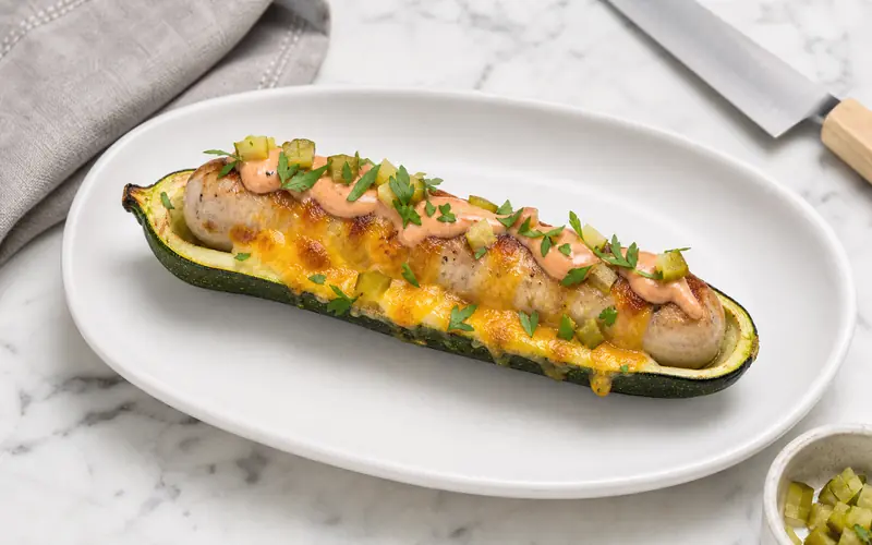 Hot dog courgette healthy garni de poulet, cheddar fondant, sauce au yaourt et cornichons croquants