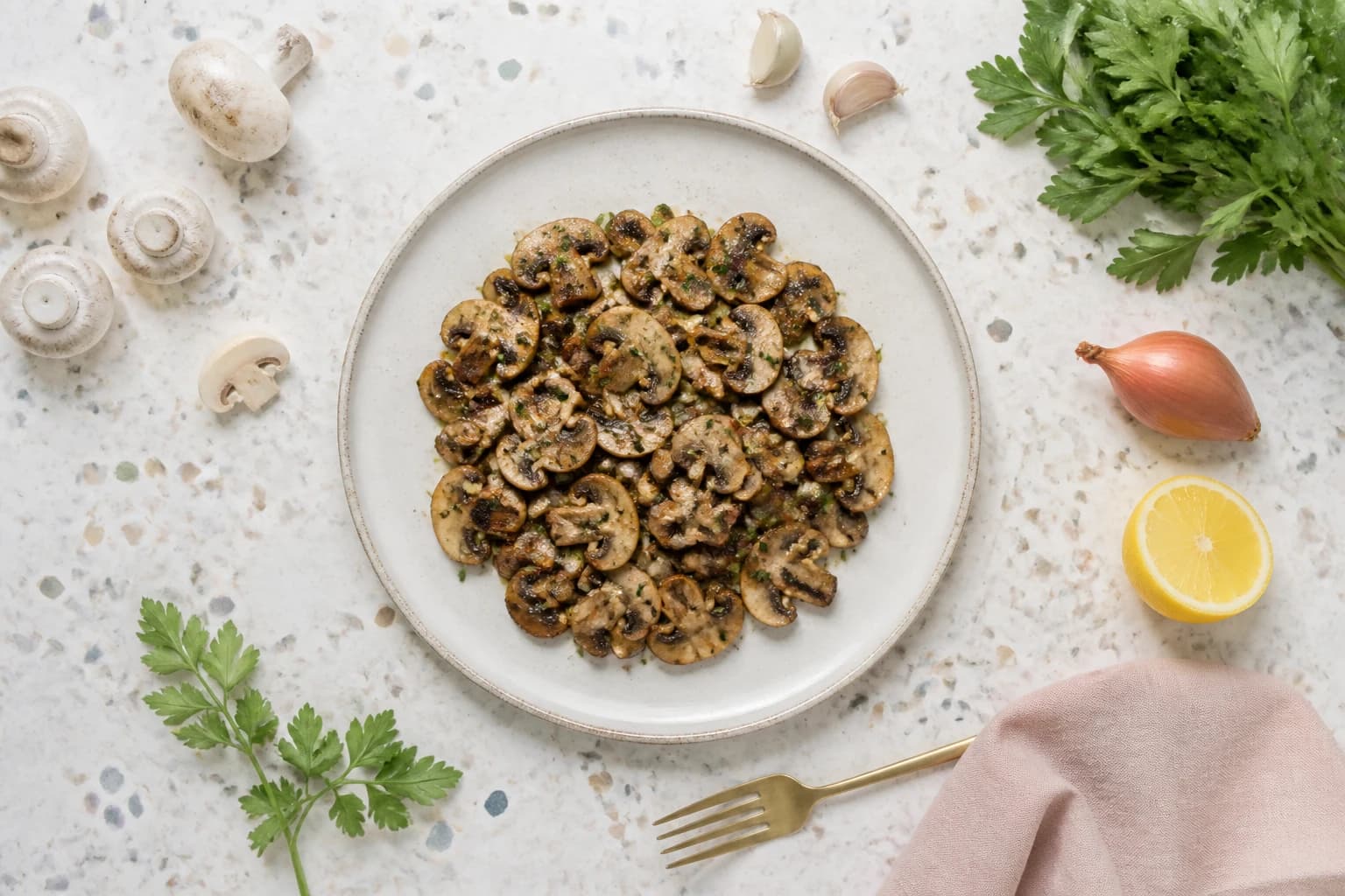 Champignons poêlés à l'ail et au persil servis avec leurs ingrédients frais autour